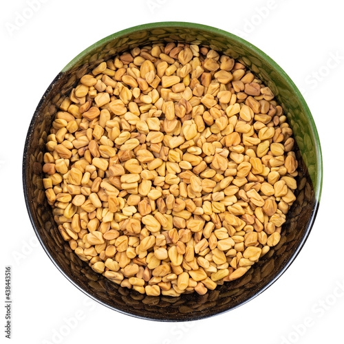 whole fenugreek seeds in round bowl isolated photo