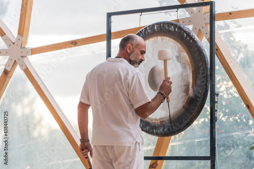 Spiritual man hitting gong photo