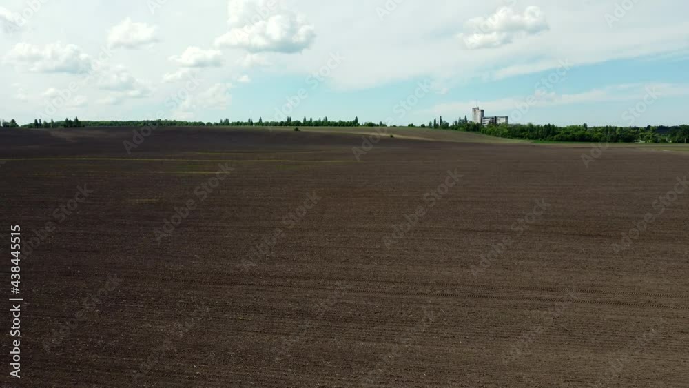 Aerial drone view flight over huge plowed field and blue sky. Aerial drone view flight over huge plowed field and blue sky.