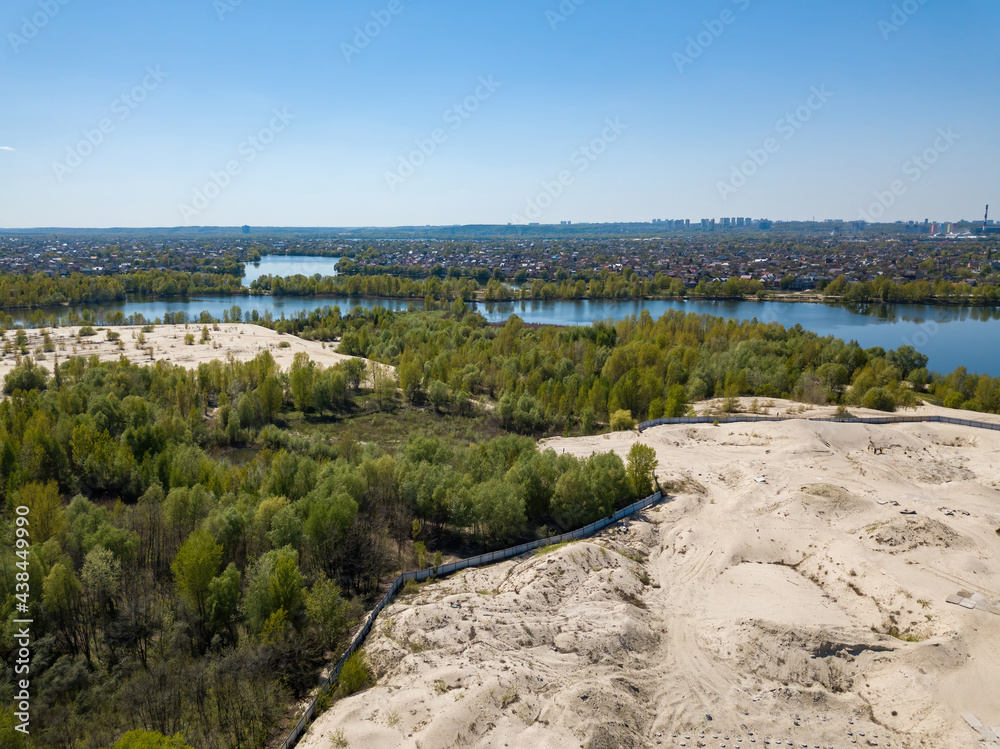 Sandy shore of the lake on the outskirts of the city. Aerial drone view.