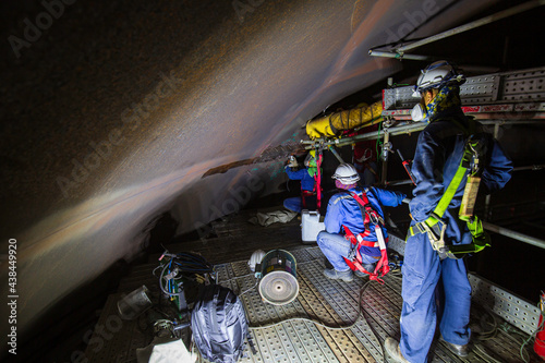 Male  worker inspection  tank of rust thickness in to confined