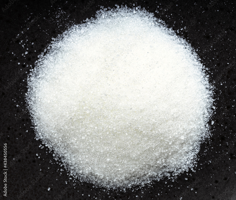 view of pile of white refined beet sugar on black