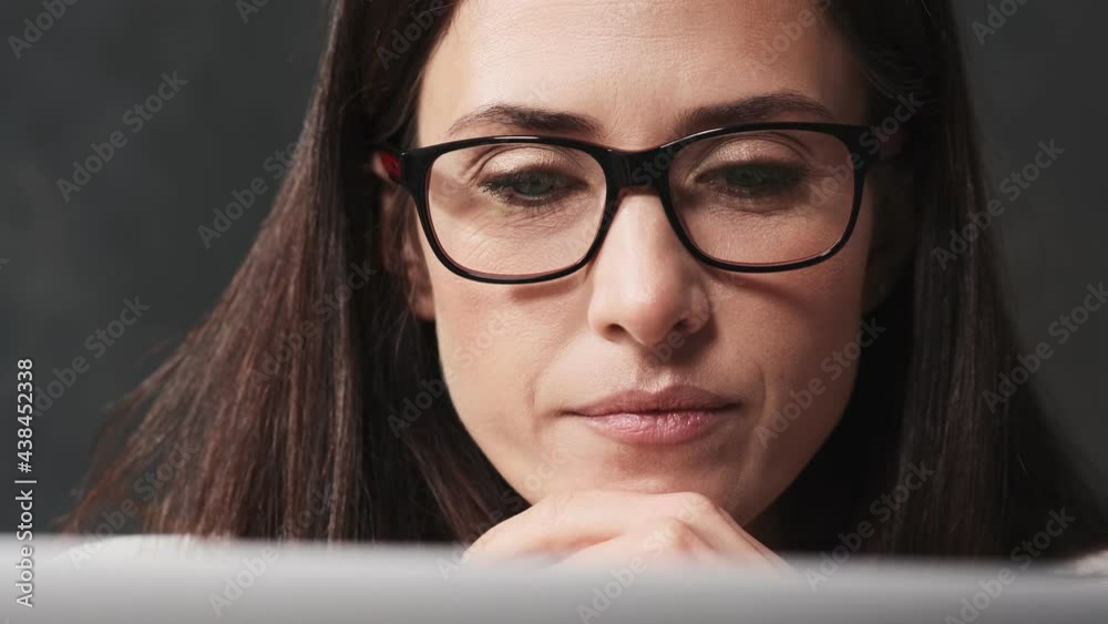 A close-up view of a thinking businesswoman is using her laptop computer sitting at the table in the office