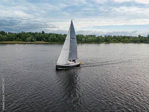 Sailing yacht floats on the river. Aerial drone view.