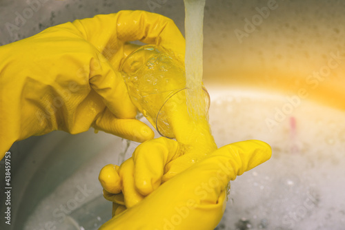 Scientist washes a test tube after a chemical experiment and a medical experiment. Man in yellow gloves