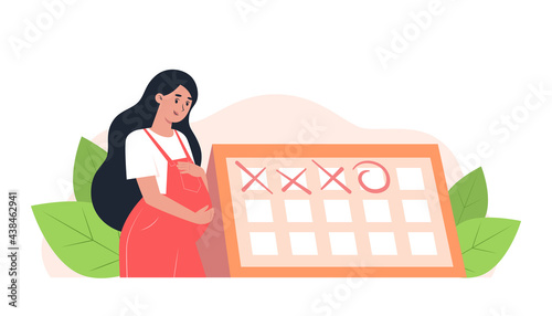 Happy pregnant woman stands near the calendar, planned appointment with an obstetrician-gynecologist