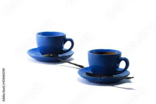 Blue tea cups and tea saucers with iron teaspoons isolated on white background