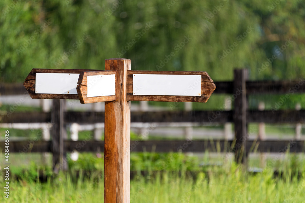 Empty wooden sign with arrows on the ranch. Simple wooden triple direction arrow roadsign. Empty wooden sign with arrows on the ranch. Simple wooden triple direction arrow roadsign.