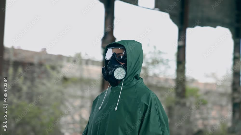 Man in gas mask and protective clothing. Man in gas mask and cloak for chemical protection on abandoned factory Man in gas mask and protective clothing. Man in gas mask and cloak for chemical protection on abandoned factory