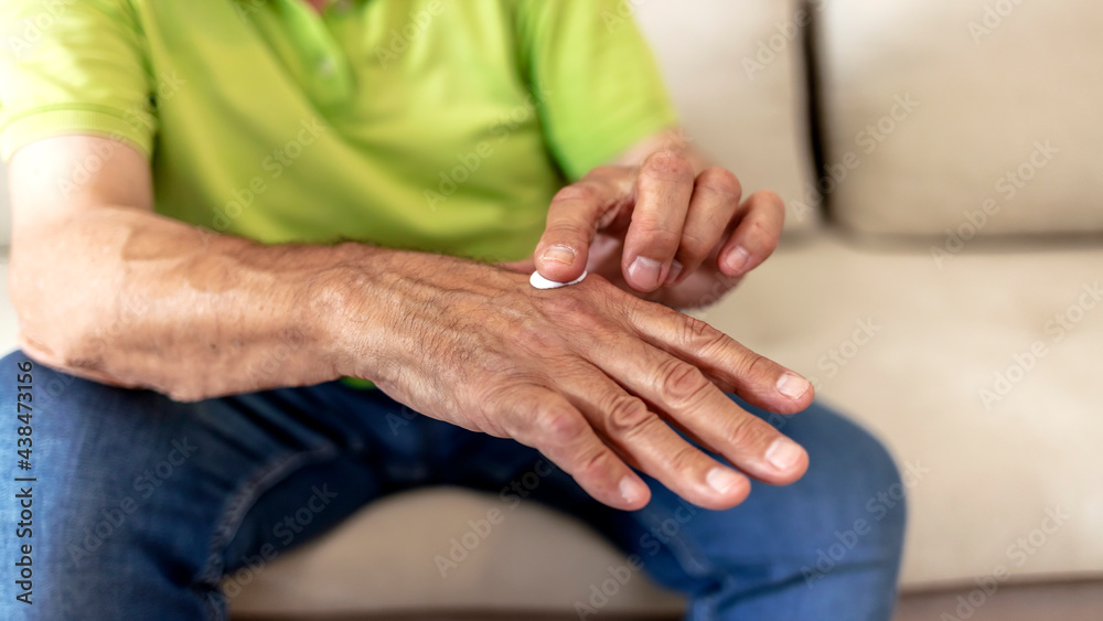 Cropped shot of unrecognized Caucasian man applying moisturizer to his hands. Cropped shot of an unrecognizable man applying lotion. Man applying hand cream at home, close up. Copy space. Cropped shot of unrecognized Caucasian man applying moisturizer to his hands. Cropped shot of an unrecognizable man applying lotion. Man applying hand cream at home, close up. Copy space.