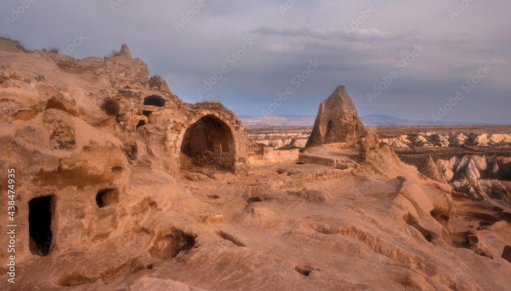 Ancient city of Uchisar with residential dwellings in caves, Cappadocia Turkey  on sunset