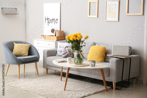 Interior of stylish living room with vase and yellow roses