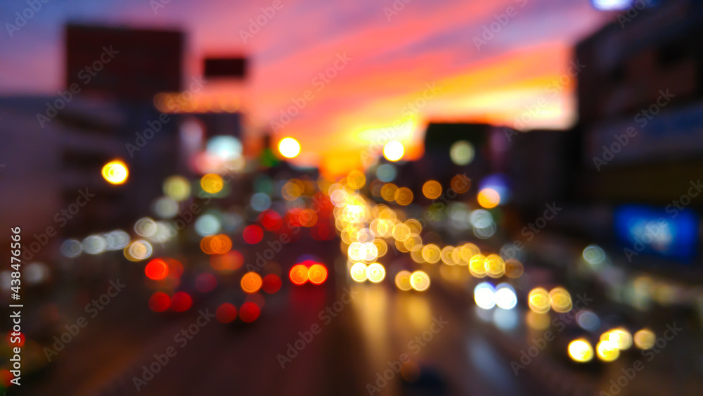 Bokeh from car lights on a street at dusk.