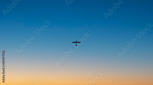 Airplane on the background of a clear blue sky at sunset (ID: 438477502)