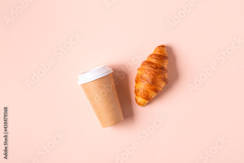 Coffee to go in a paper cup with croissants.