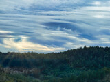 Epic cloudscape at sunset over forested mountain ridge