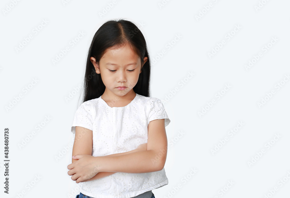 Portrait of Asian little child girl with arms crossed and acting all sad over white background with looking down. Person with Negative emotion concept. Portrait of Asian little child girl with arms crossed and acting all sad over white background with looking down. Person with Negative emotion concept.