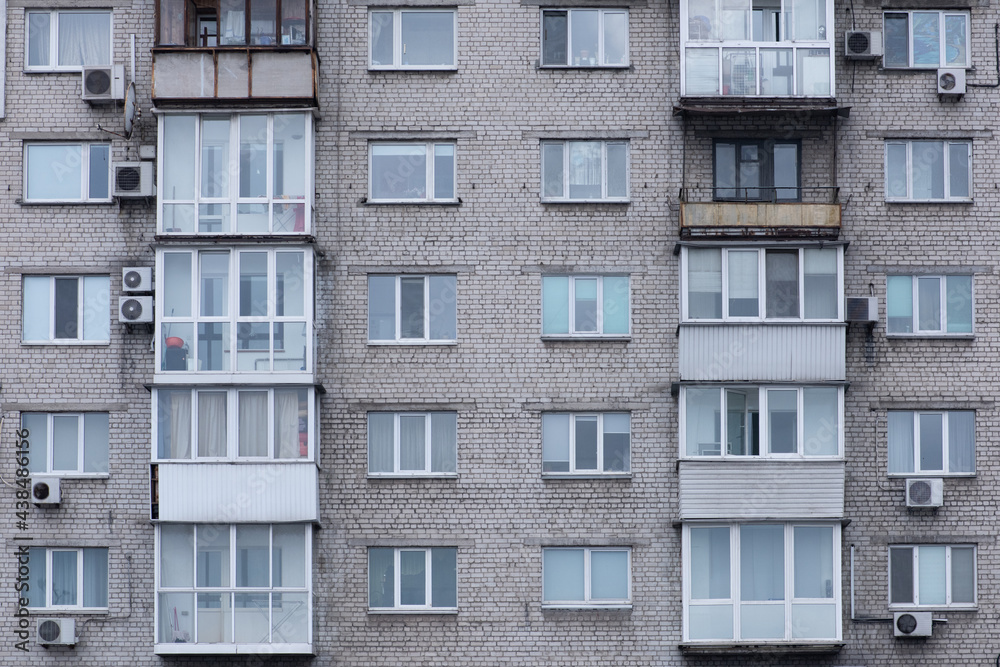 facade of a gray communist house with balconies and air conditioning