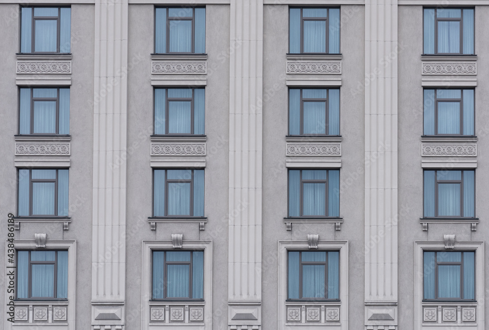 building facade with gray walls and decor between windows