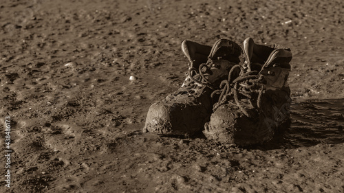 Muddy work shoes in the beach in sepia tone