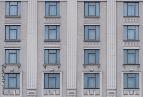 building facade with gray walls and decor between windows