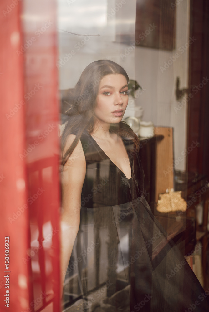Naklejka premium Young woman wearing black dress and preparing for a date
