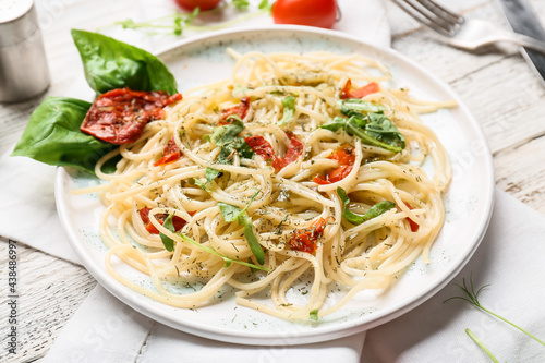 Plate with tasty pasta on light wooden background