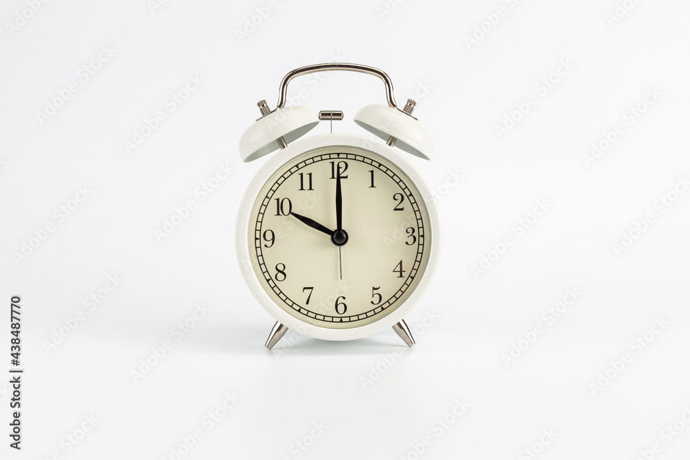 White retro clock alarm clock on white background shows 10 am or 10 pm or 10:00 or 22:00 White retro clock alarm clock on white background shows 10 am or 10 pm or 10:00 or 22:00