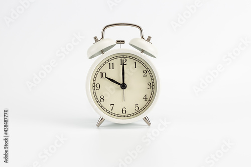 White retro clock alarm clock on white background shows 10 am or 10 pm or 10:00 or 22:00