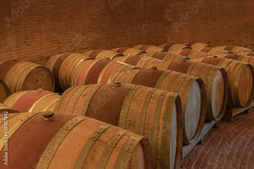 2019-11-05 SEVERAL WOODEN WINE CASKS LINED UP IN A BRICK CELLAR