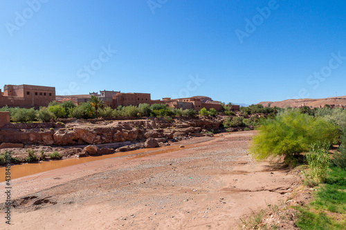 Terracotta landscape with an Ait Benhaddou Kasbah and dry riverbed of Ounila River in near Ouarzazate city Morocco, North Africa in october.