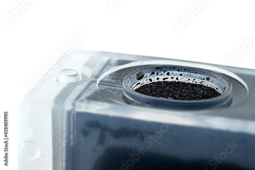 Macro photo of a black ink cartridge for a color printer, isolated on white background.