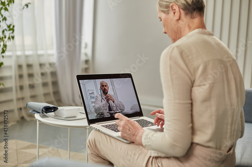An elderly woman communicates remotely via a laptop with her doctor. Telemedicine concept