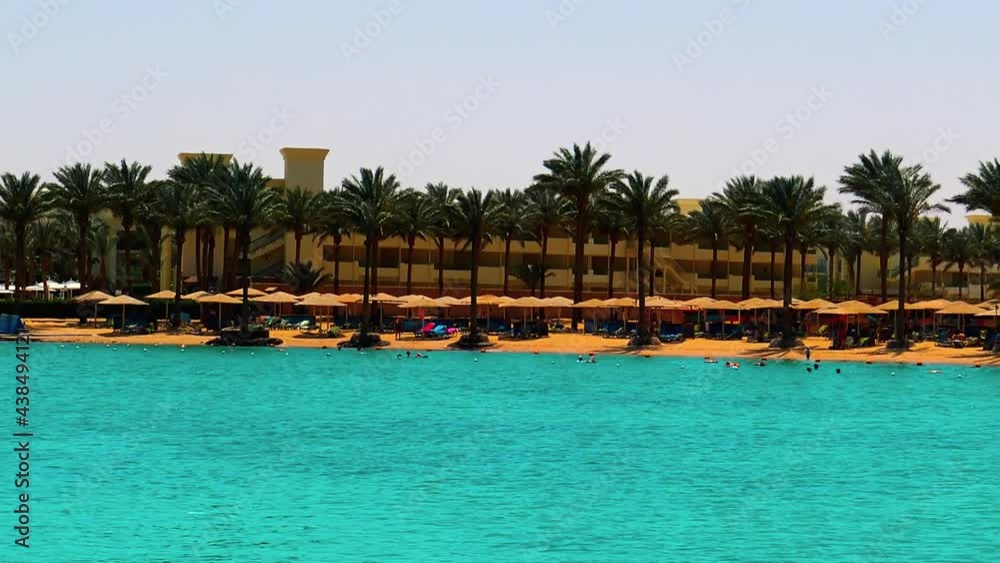 A sea view over Red Sea beach with people during sunny summer day in Hurghada, Egypt. A sea view over Red Sea beach with people during sunny summer day in Hurghada, Egypt.