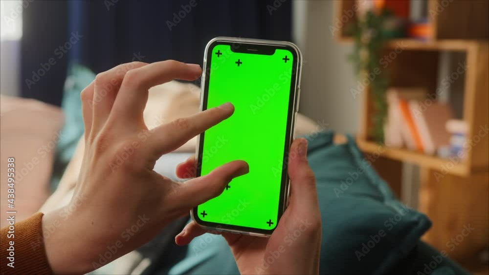 Close-up of smartphone with green screen, young man hands holding mobile phone, zoom in, isolate display, touch screen, chroma key phone concept, surfing the internet with gadgets. Close-up of smartphone with green screen, young man hands holding mobile phone, zoom in, isolate display, touch screen, chroma key phone concept, surfing the internet with gadgets.