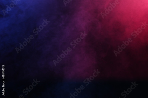 Artificial magic smoke in red-blue light on black background