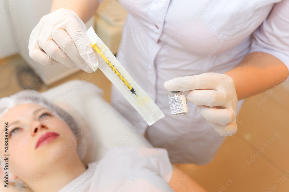the cosmetologist holds a packed syringe in front of the client's face the cosmetologist holds a packed syringe in front of the client's face
