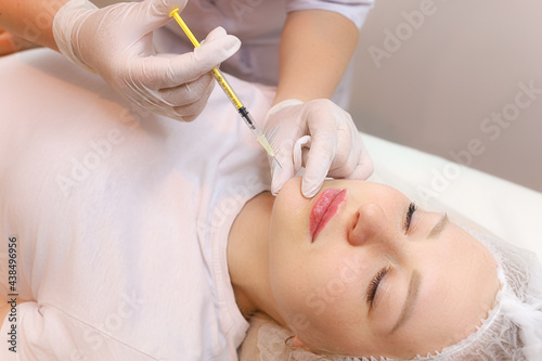 The cosmetologist performs the chin lift procedure by injecting beauty injections