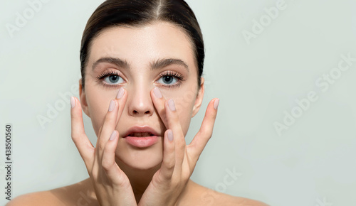 Wallpaper Mural Beautiful young woman with clean perfect skin. Portrait of beauty model with natural nude make up and and hand with manicure touching face. Spa, skincare and wellness Torontodigital.ca