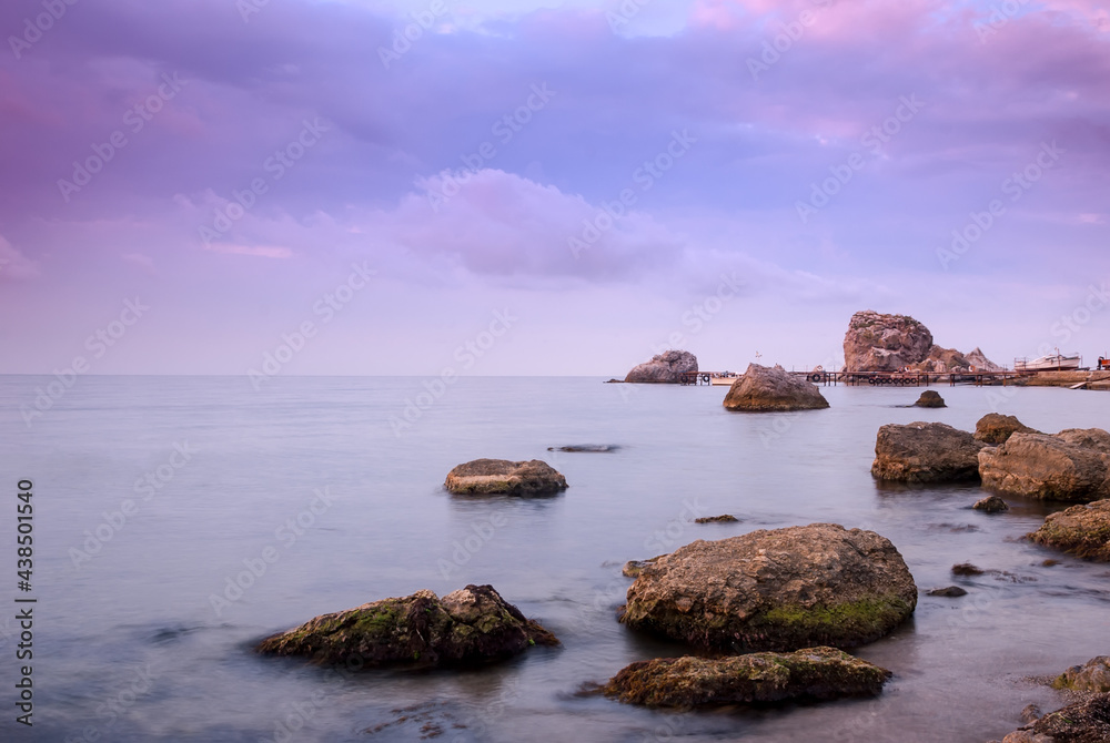 Morning seascape. Sea water at long exposure, stones and rocks. Beautiful sky with clouds. Morning seascape. Sea water at long exposure, stones and rocks. Beautiful sky with clouds.