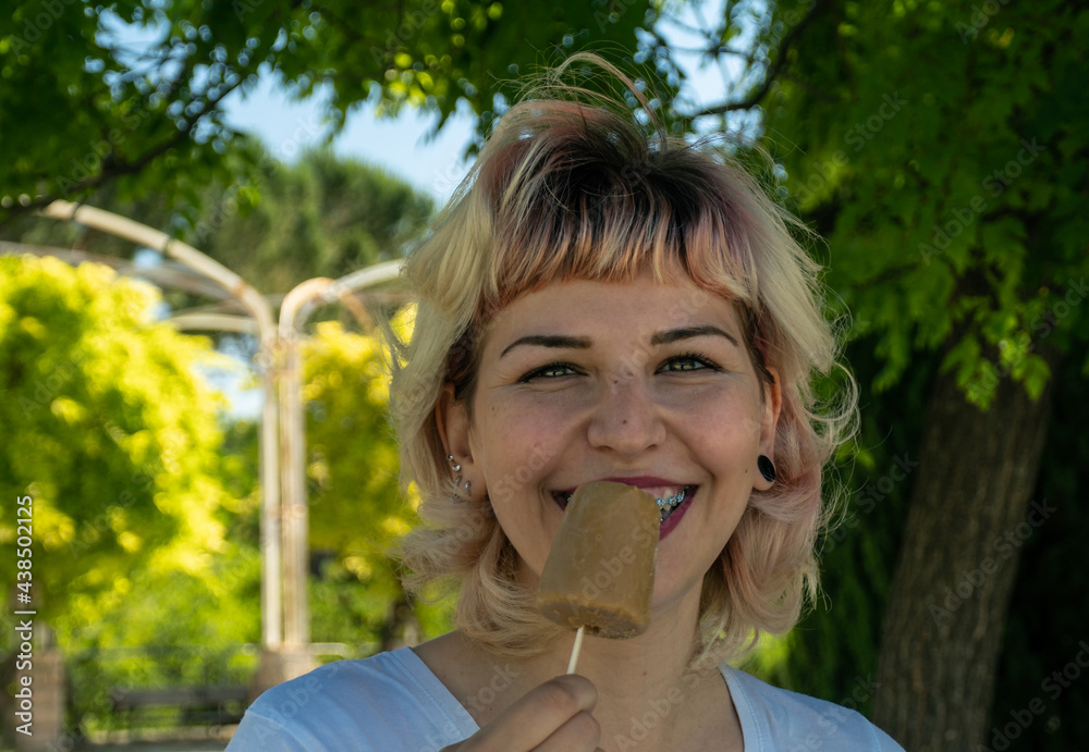 Chica feliz con un helado en la mano en el parque, chica con Brackets comiendo un helado Chica feliz con un helado en la mano en el parque, chica con Brackets comiendo un helado