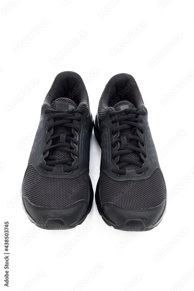 Black sneakers isolated on white background. Stylish black sneaker made from a combination of faux leather and textile material and rubber sole. Casual shoes. Running shoes.