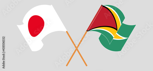 Crossed and waving flags of Japan and Guyana