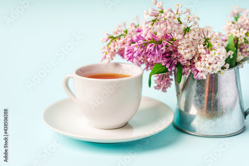Beautiful minimalist background with floral composition and tea mug, copy space on light blue backround