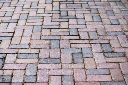 Sidewalk paved with red and gray rectangular tiles in perspective