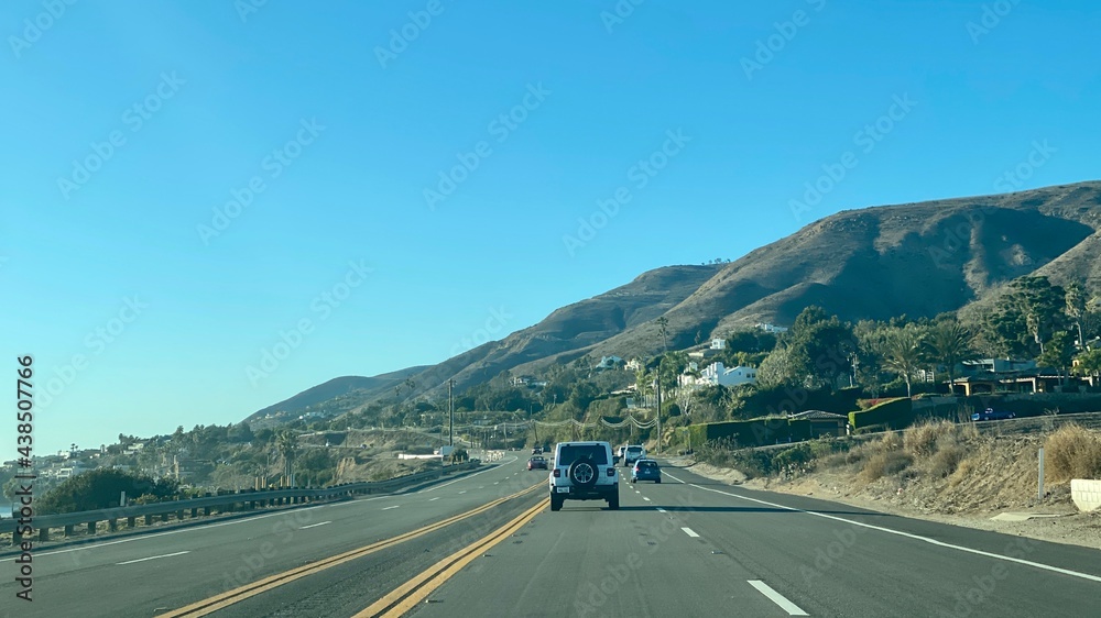 MALIBU, CA, DEC 2020: view looking north, driving on Pacific Coast Highway 1 with the Pacific Ocean on left