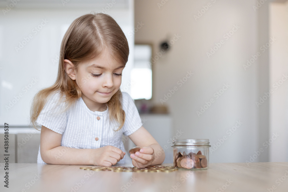 Kid saving money putting coins into glass bank, Concept finance business investment, money saving. Kid saving money putting coins into glass bank, Concept finance business investment, money saving.