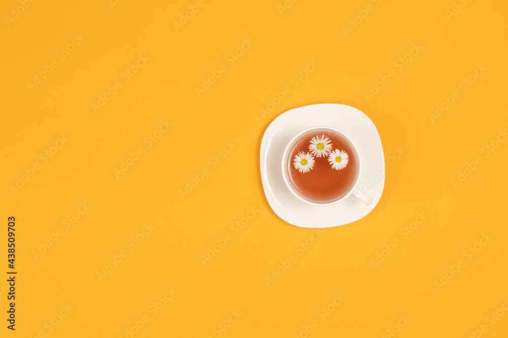 Cup of tea with flowers isolated on yellow background top view with copy space for text Cup of tea with flowers isolated on yellow background top view with copy space for text
