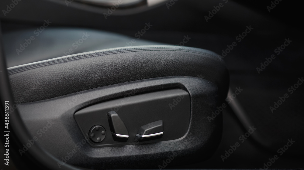 Car seat electronic switch button. lever for electronic seat adjustment in a modern premium car. Seat memory option. Close up of seat bottoms.