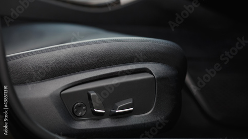 Car seat electronic switch button. lever for electronic seat adjustment in a modern premium car. Seat memory option. Close up of seat bottoms.